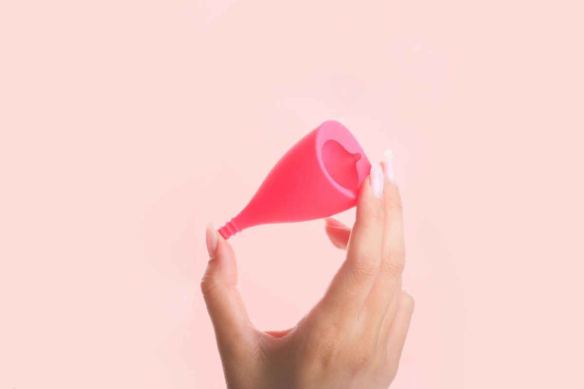 Intimina Lily Cup - Long menstrual cup being held in a hand