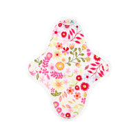 Reusable cloth pad with white base and colorful flower print; stitched edge with snap tab