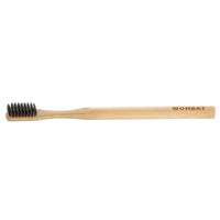 Bamboo toothbrush with charcoal bristles and Wombat logo on handle