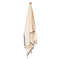 Turkish towel sarong draped view, cream with navy stripe detail and tassel fringe.