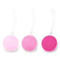 Three pink weighted kegel balls with white hanging cords